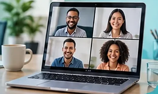 A laptop showing four smiling participants on a video call